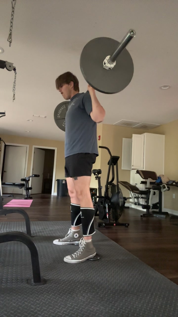 Spencer standing with a barbell during a back squat session